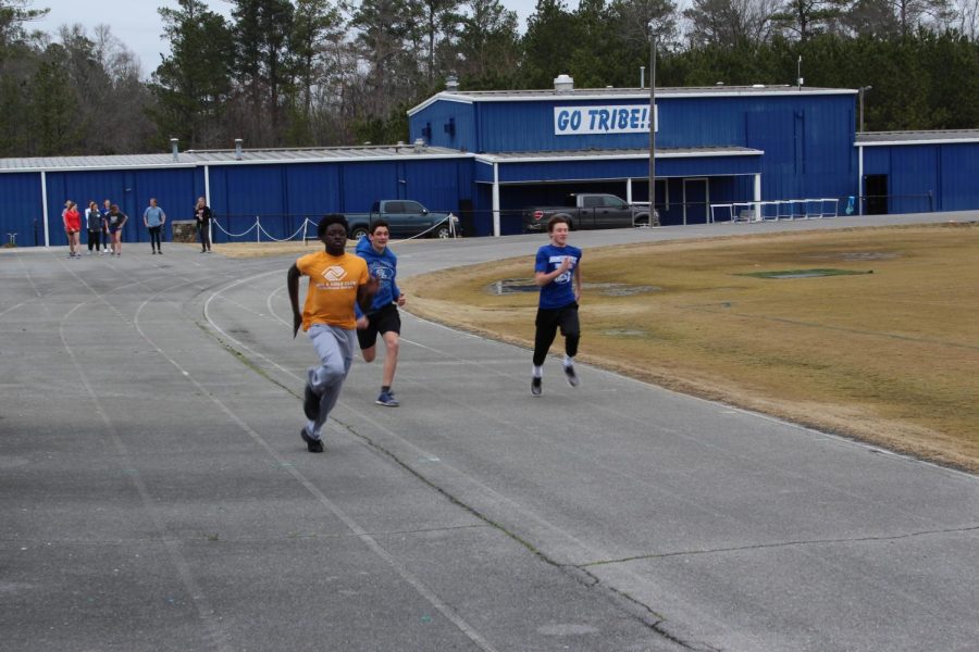 Sprinters Sylvester Bassey, Devin Cromer, and Brayden Presley Sprinting the 100 meter dash.