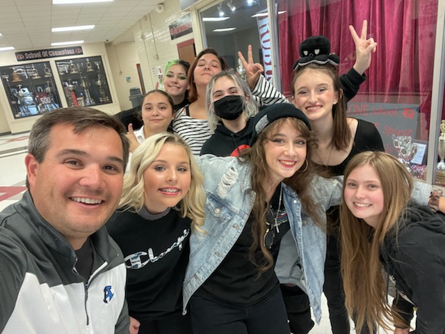 Drama club snapping a picture with Principal Rhodarmer