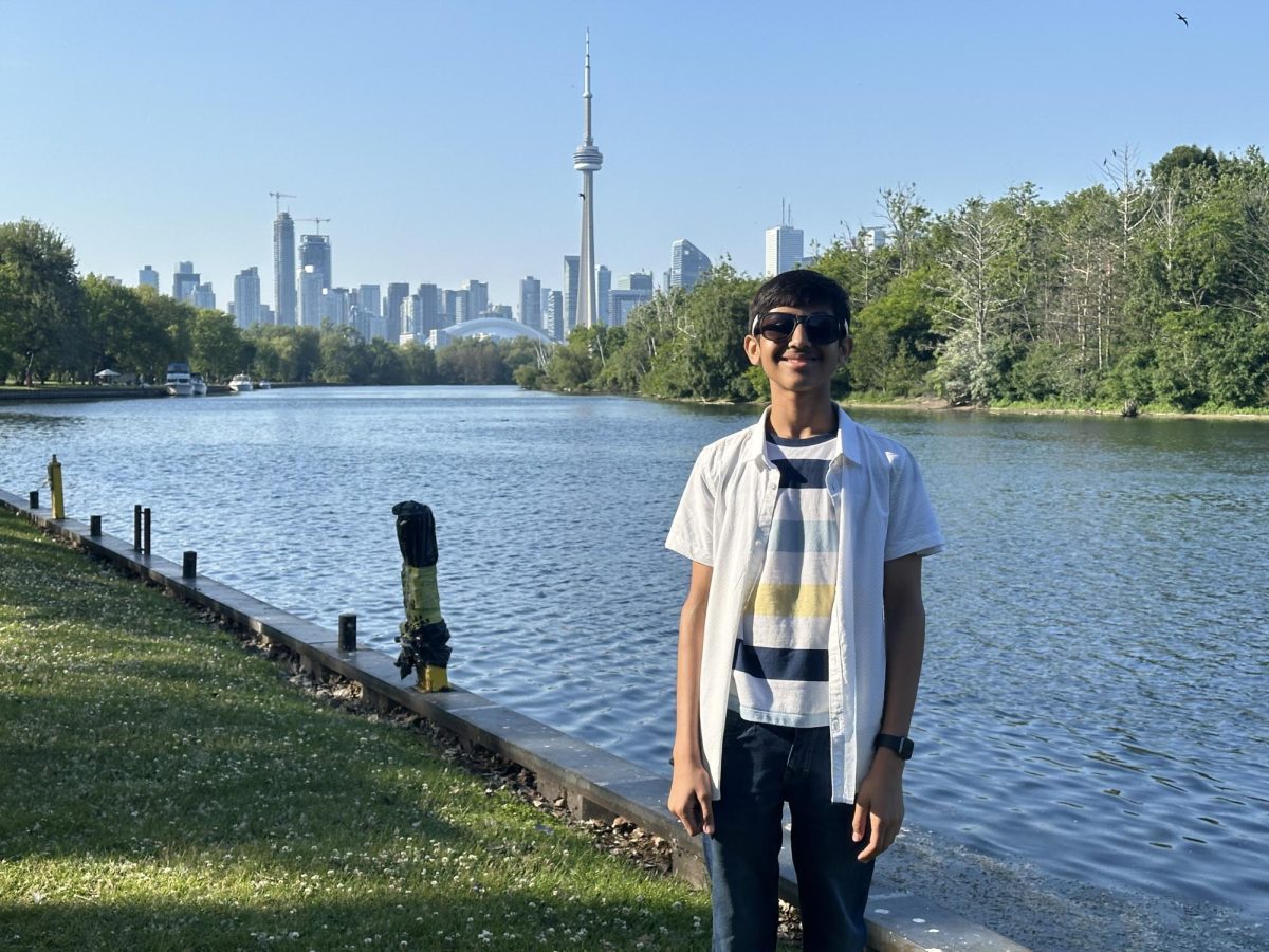 A photograph of me standing on Centre Island, Toronto, with the city skyline and CN Tower visible across the river in the background.