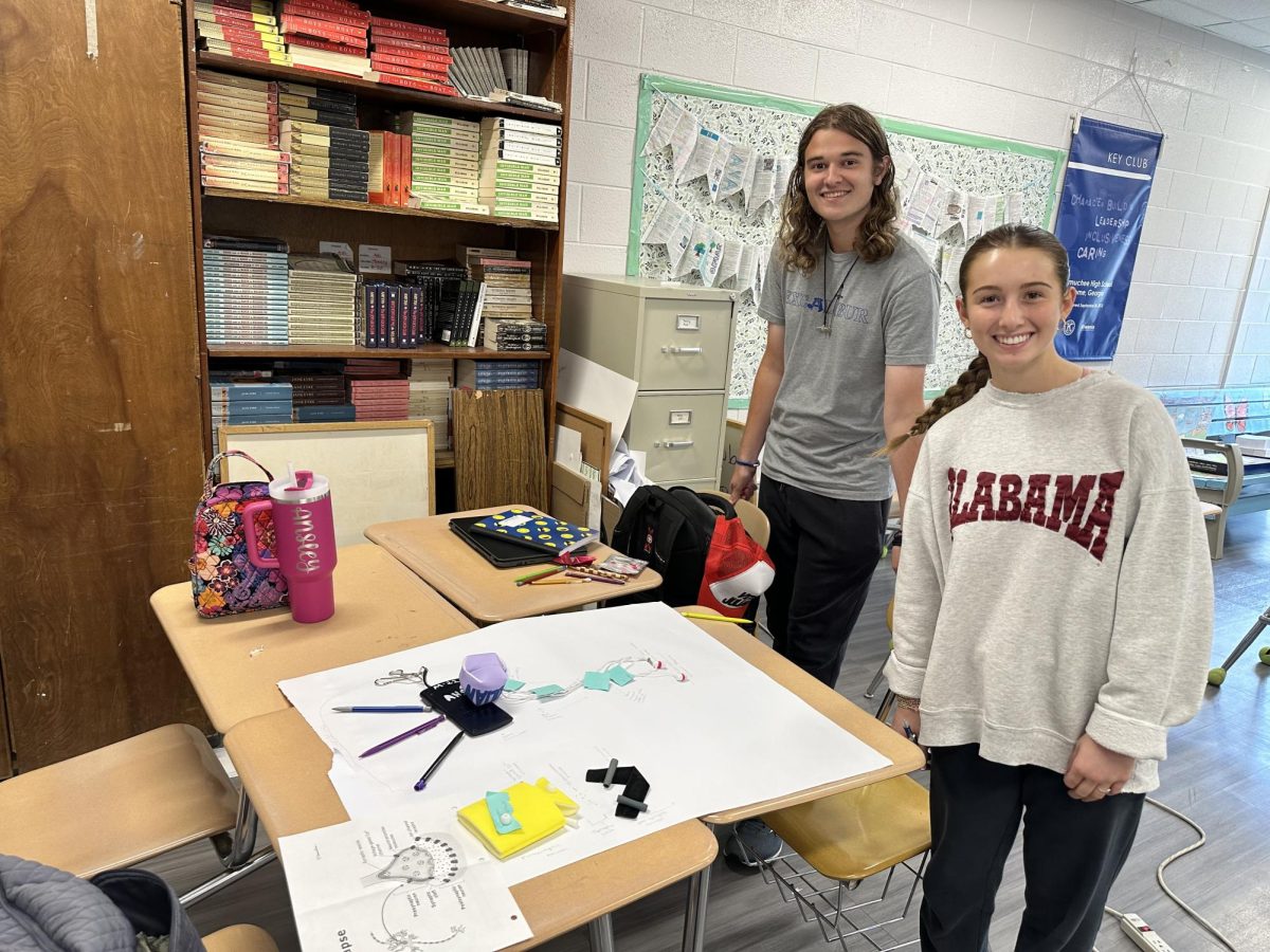 AP Psychology students posing for a picture with one of their projects.